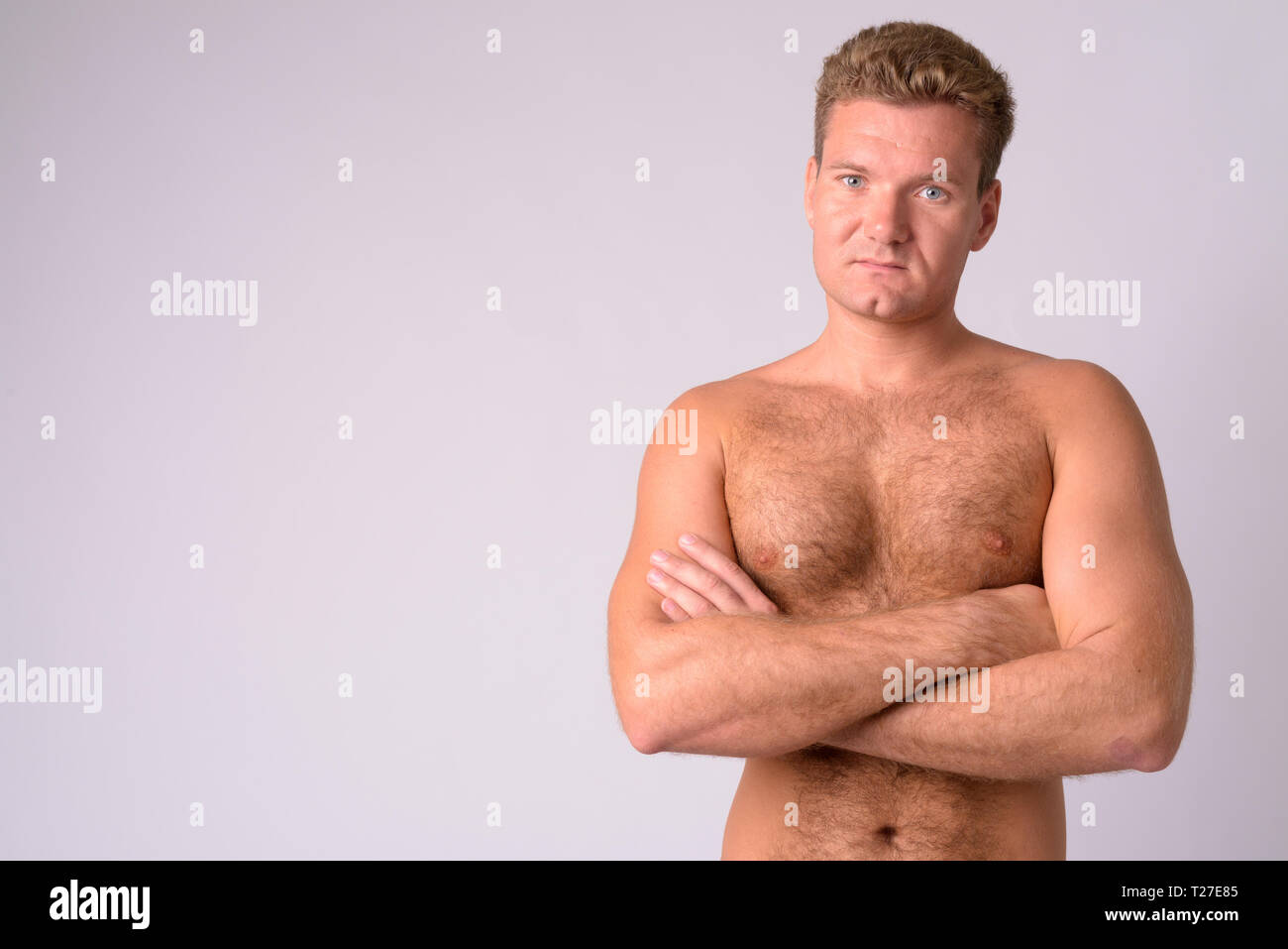 Portrait Of Young Blonde Shirtless Man With Chest Hair Crossing