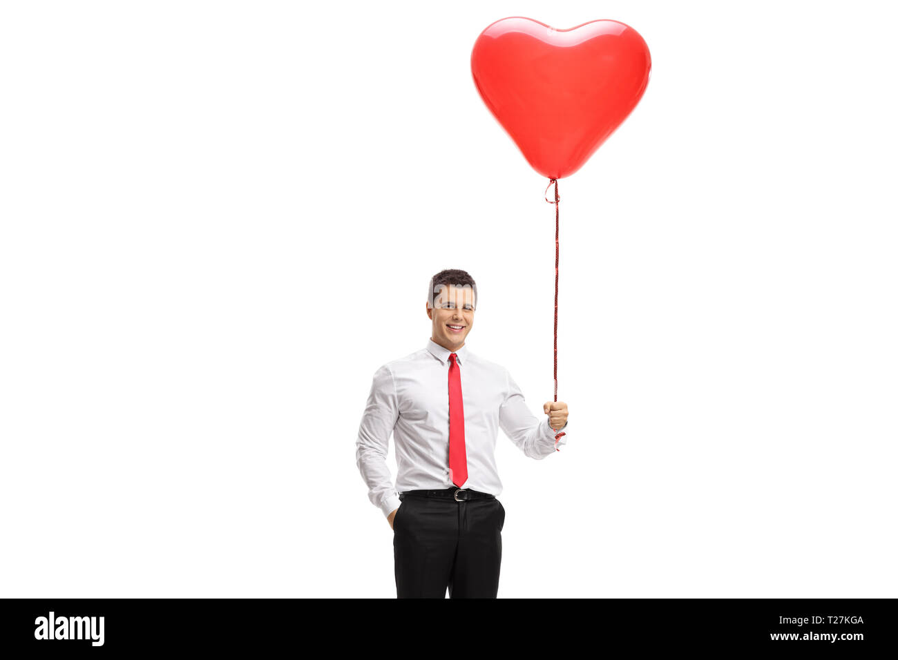 Young man holding a heart shaped balloon isolated on white background Stock Photo