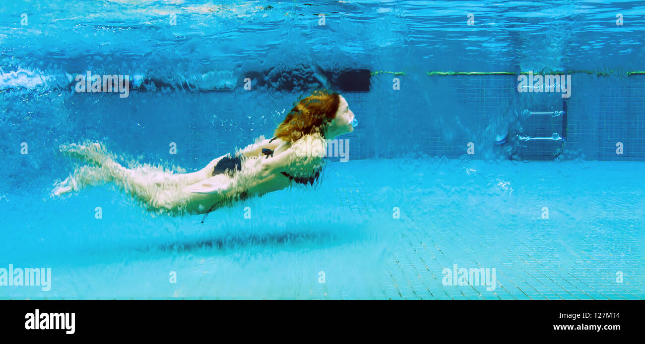 Woman swimming underwater in a glass swimming pool Stock Photo - Alamy