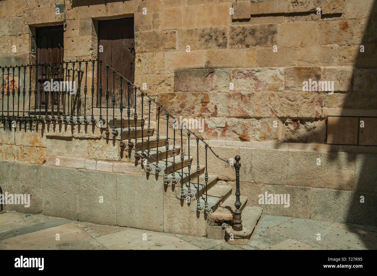 Old building on alley and stone staircase with wrought iron railing at ...