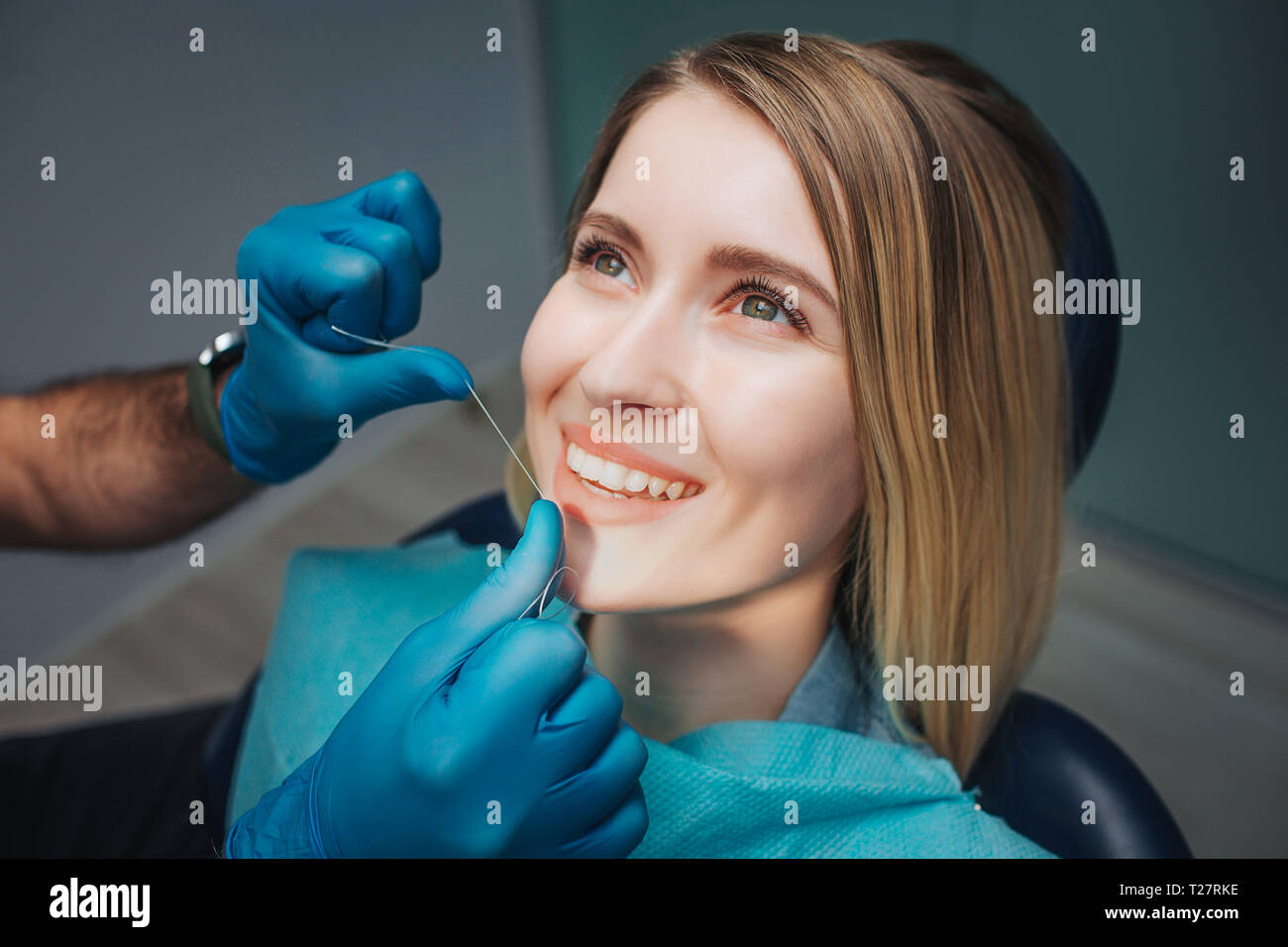 Young woman sit in dentistry in chair and look up. Doctor use teeth
