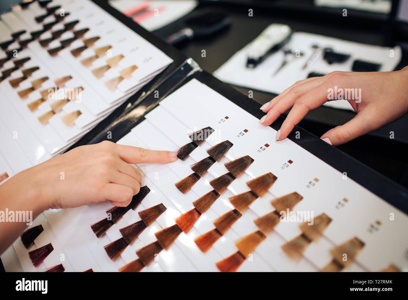 Close-up of woman choosing dark color hair from palette on white background Stock Photo