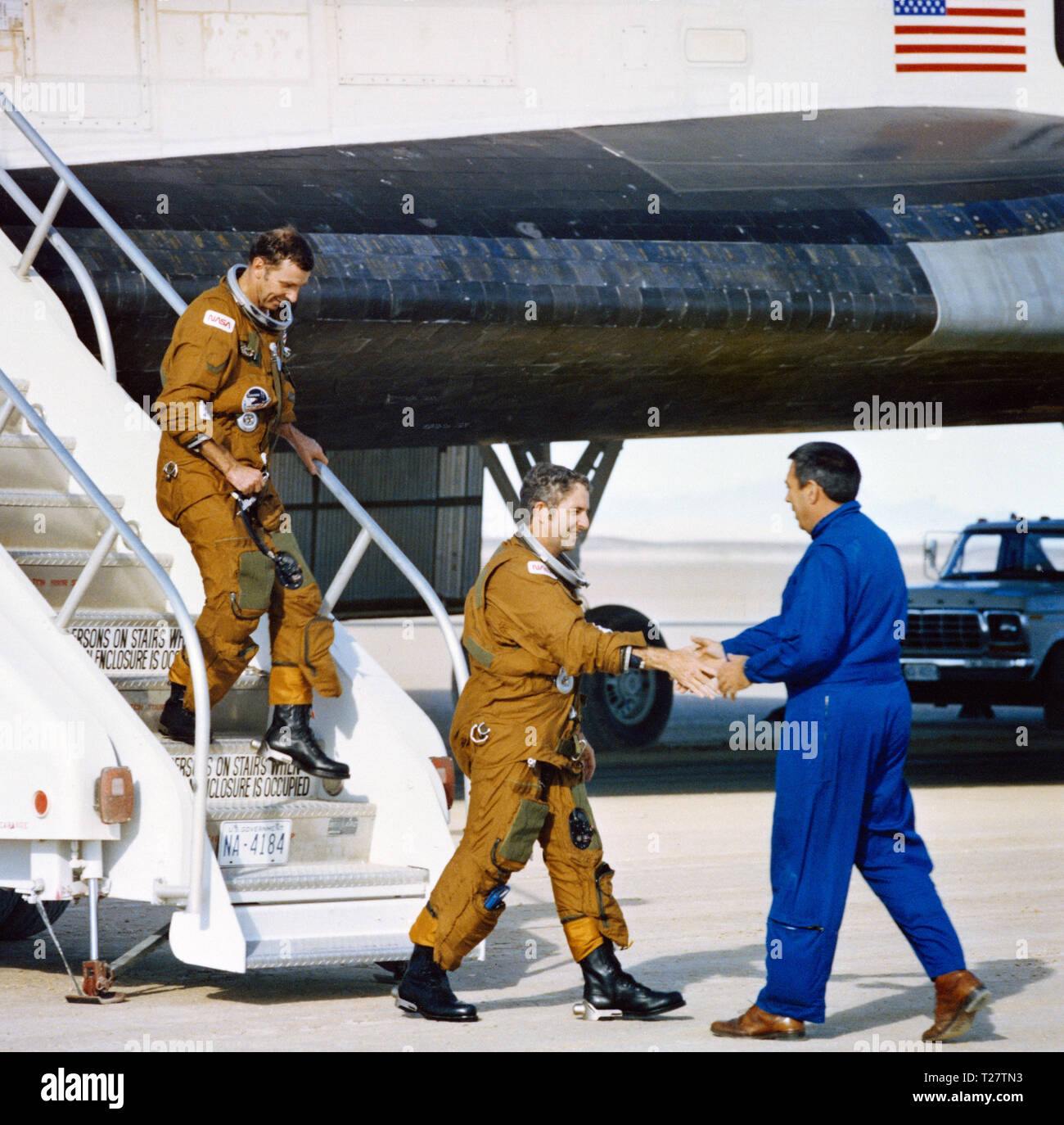 (14 Nov. 1981) --- Astronauts Joe H. Engle, rear, and Richard H. Truly are greeted by George W.S. Abbey, Director of Flight Operations at the Johnson Space Center, as they egress the space shuttle Columbia after spending two days, six hours and 13 minutes on NASA's STS-2 mission. Stock Photo