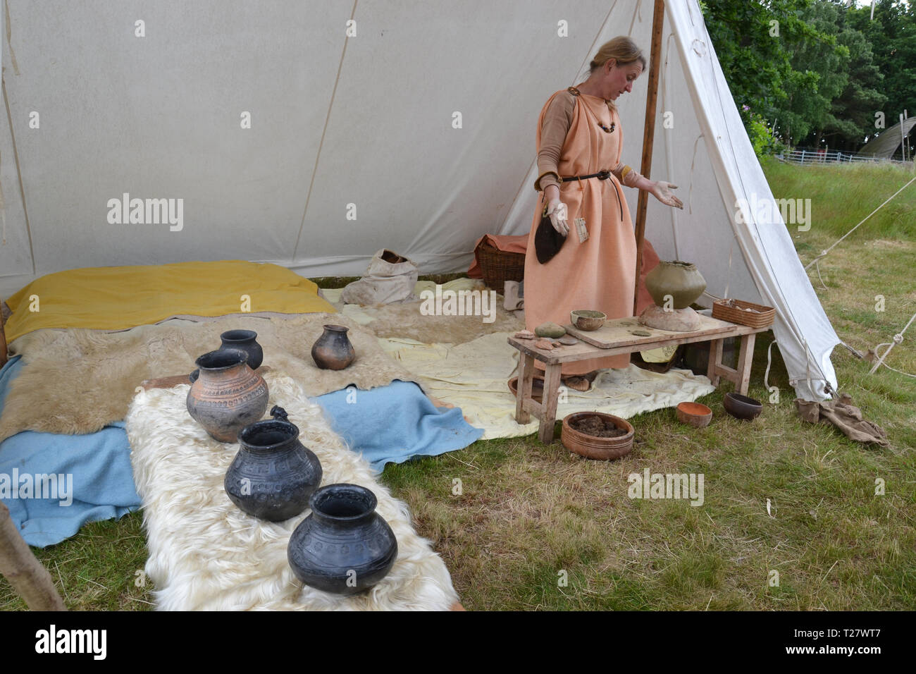 Anglo-Saxon lady re-enactor working with clay pottery at an event in Suffolk, UK Stock Photo