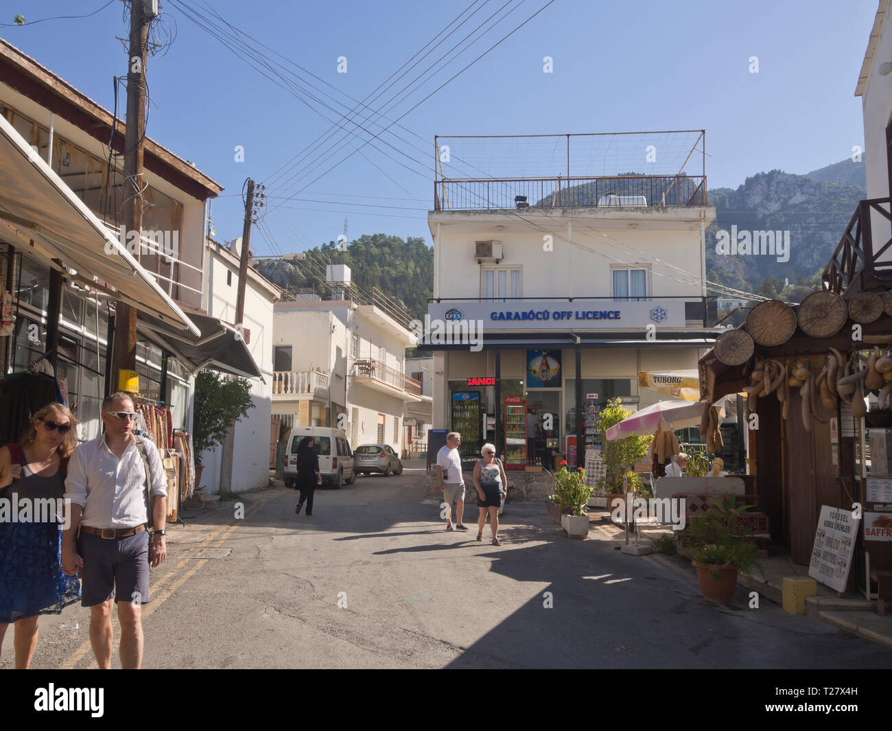 Narrow street with shops and tourists in the village of Beylerbeyi (Bellapais) in the northern part of Cyprus Stock Photo