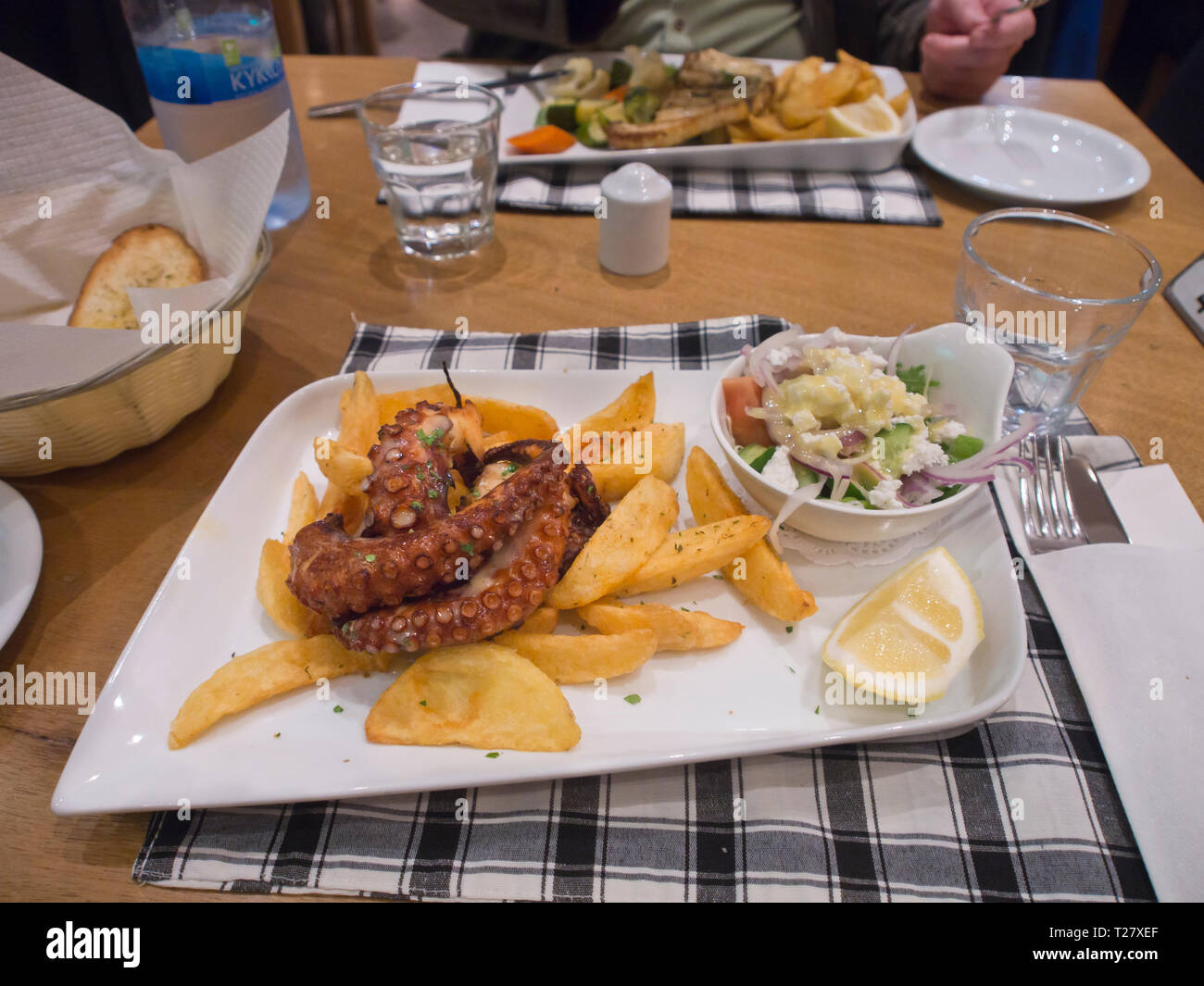 Mediterranean cuisine, grilled octopus with potatoes and salad, on a restaurant table in Ayia Napa Cyprus Stock Photo