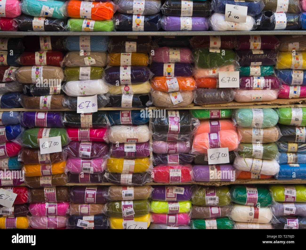 Colourful stacks of knitting yarn with price tags from a market stall