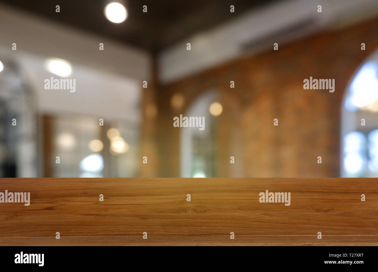 Empty wooden table in front of abstract blurred background of restaurant, cafe and coffee shop interior. can be used for display or montage your produ Stock Photo