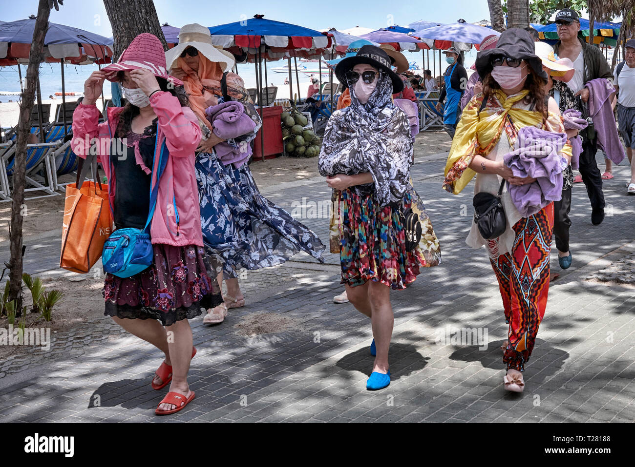 Face masks. Women wearing face masks, shawls and hats to protect against the hot sun. Pattaya, Thailand, Southeast Asia Stock Photo