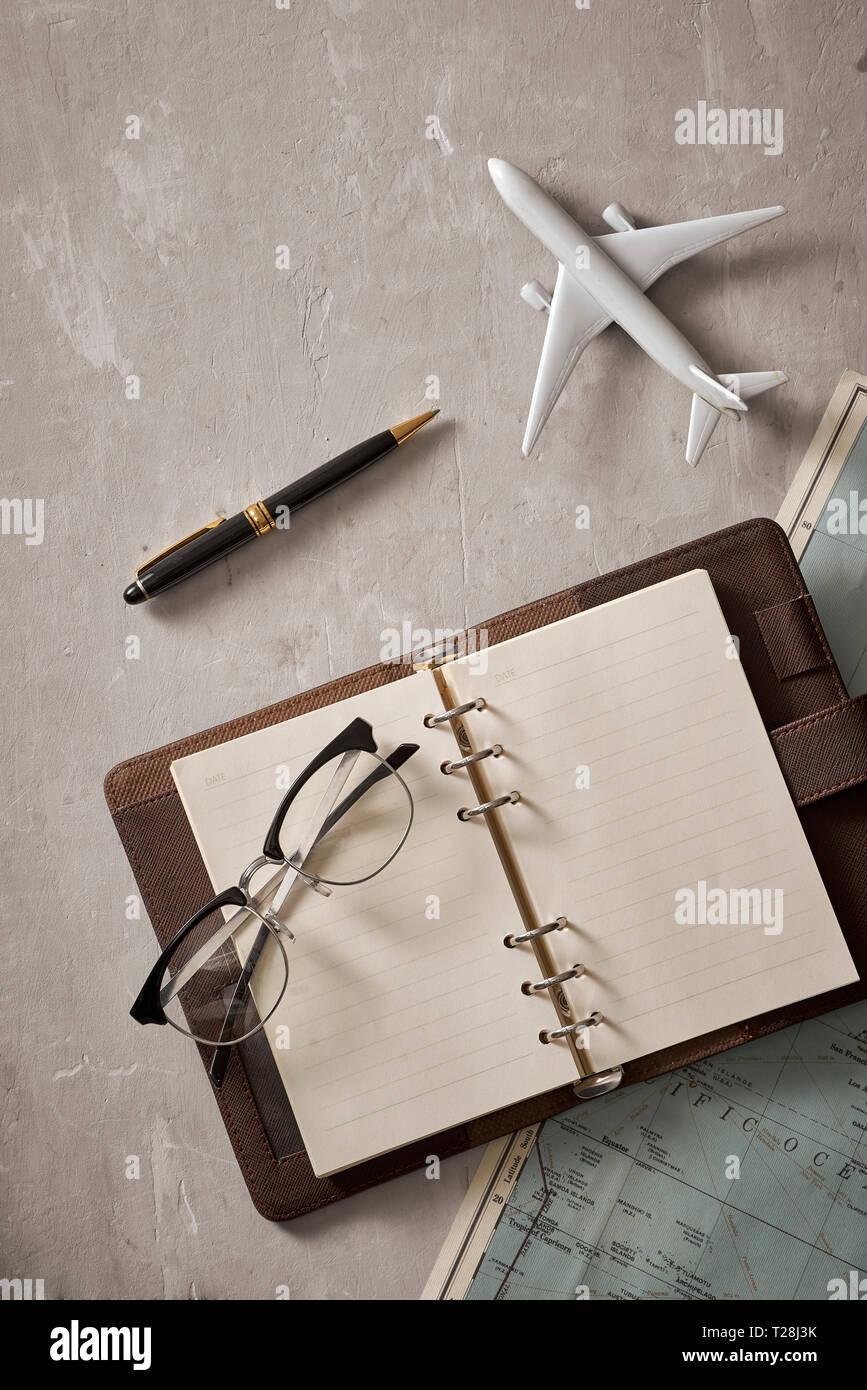 Empty white space in notebook where you can place your text or advertisement. Airplane, magnifying glasses and glasses on the map. Romantic travel Stock Photo