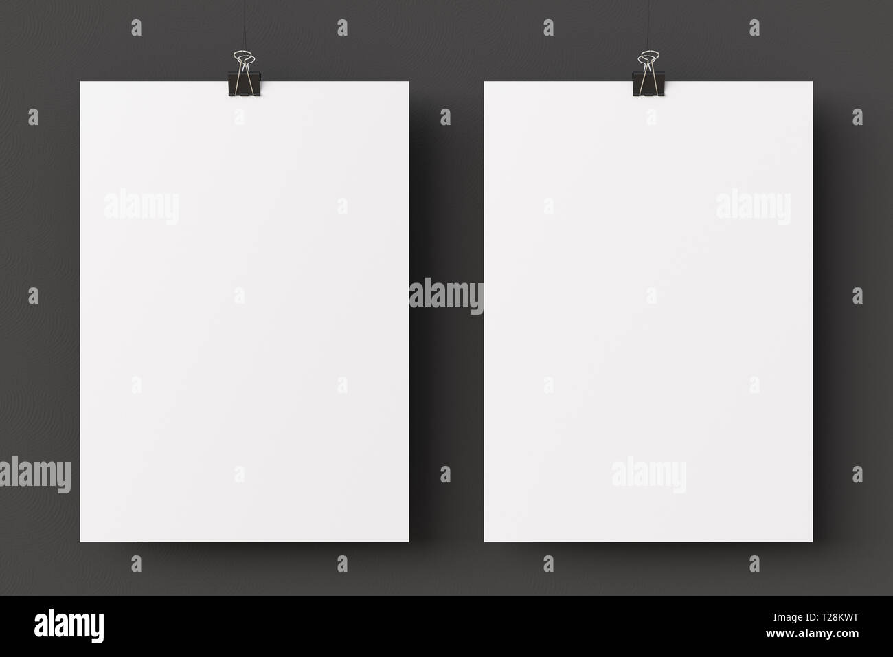Two blank paper posters hanging on binder clips on black wall