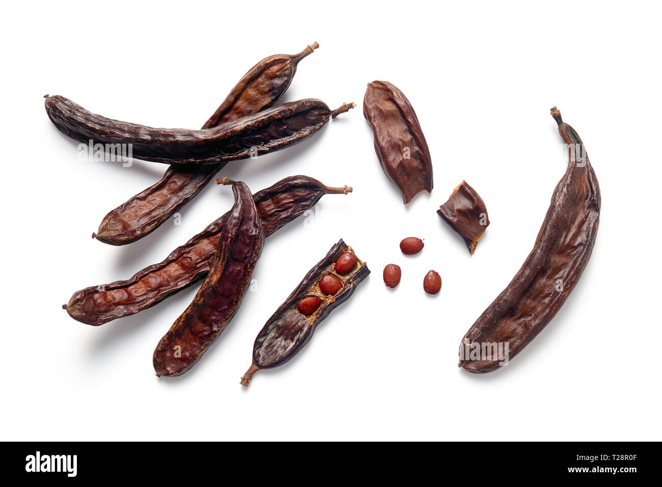 Carob bean pods and seeds on white background Stock Photo
