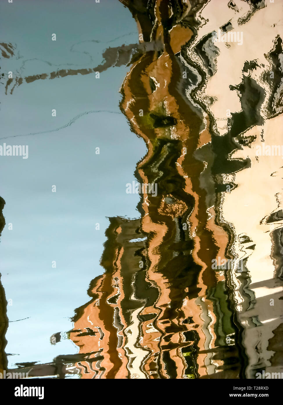 The houses of Venice reflected on the water of a canal form an abstract ...