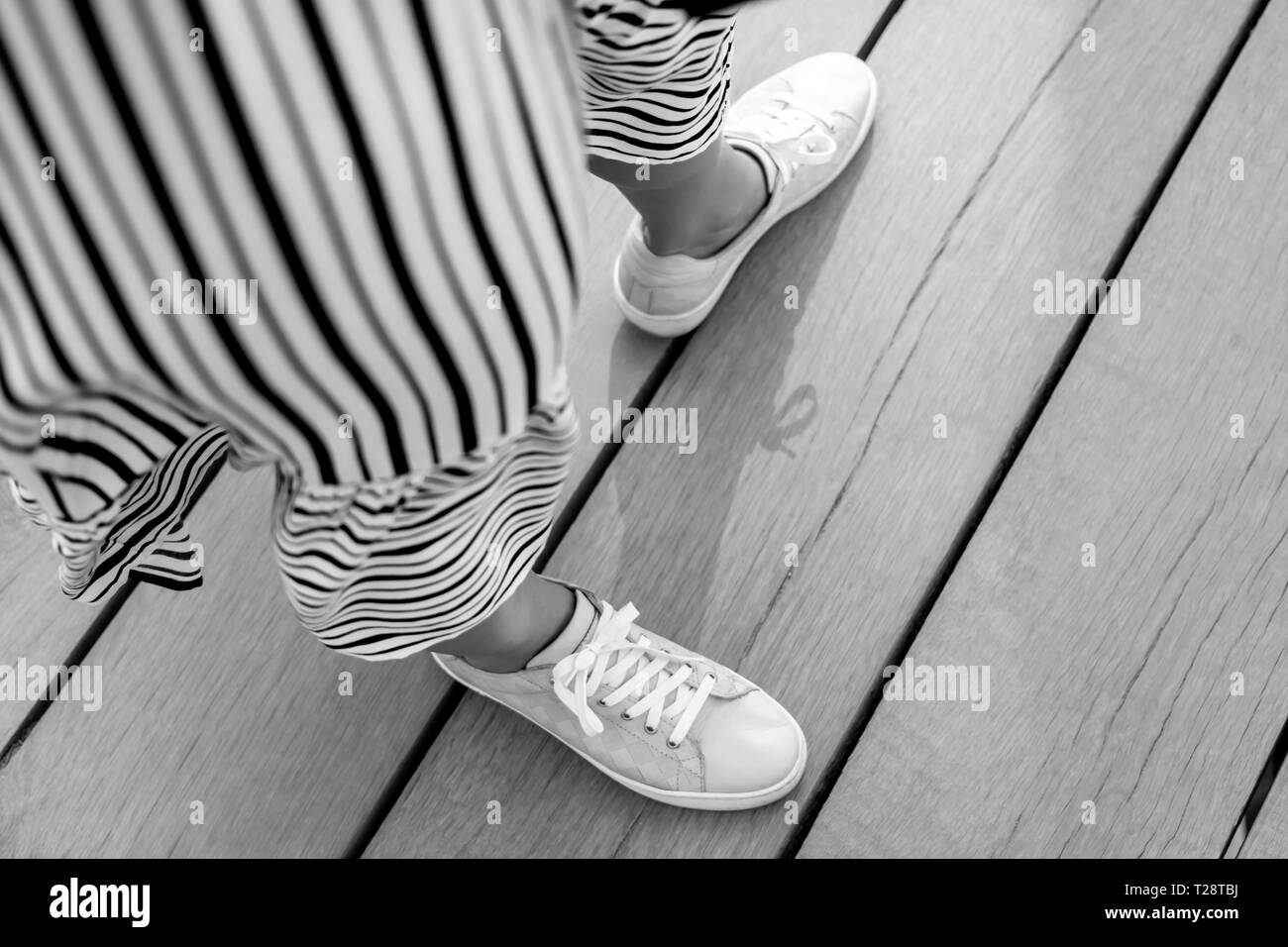 woman dress and feet in sneakers in motion Stock Photo