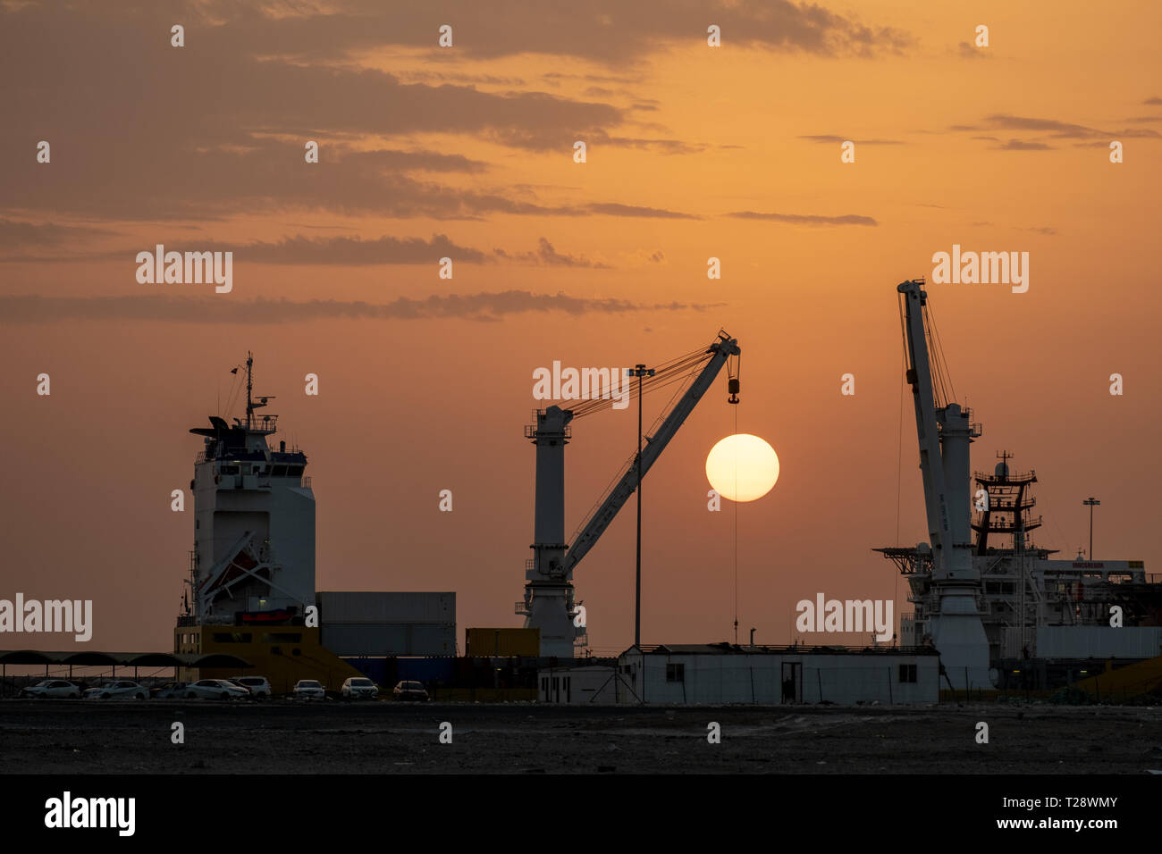 Lifting Crane mounted on Cargo ship during sunset Stock Photo