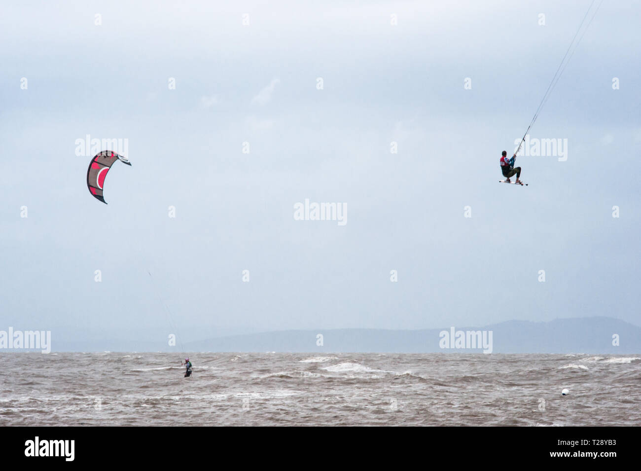 Kite surfers and kite boarders getting some air on Morecambe Bay, England. Stock Photo