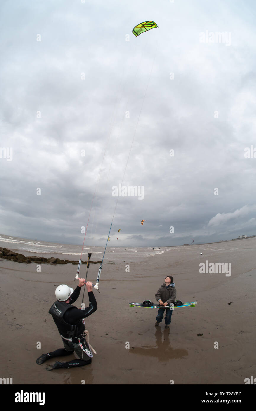A man shows his son how to fly a power kite. Stock Photo
