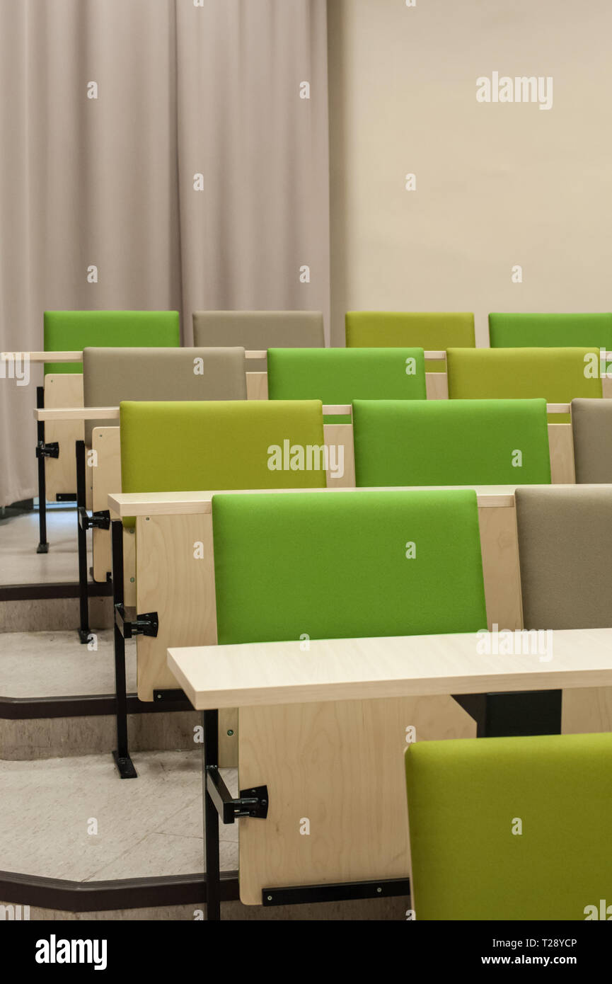 Colourful green seat covers in a university lecture theatre. Stock Photo