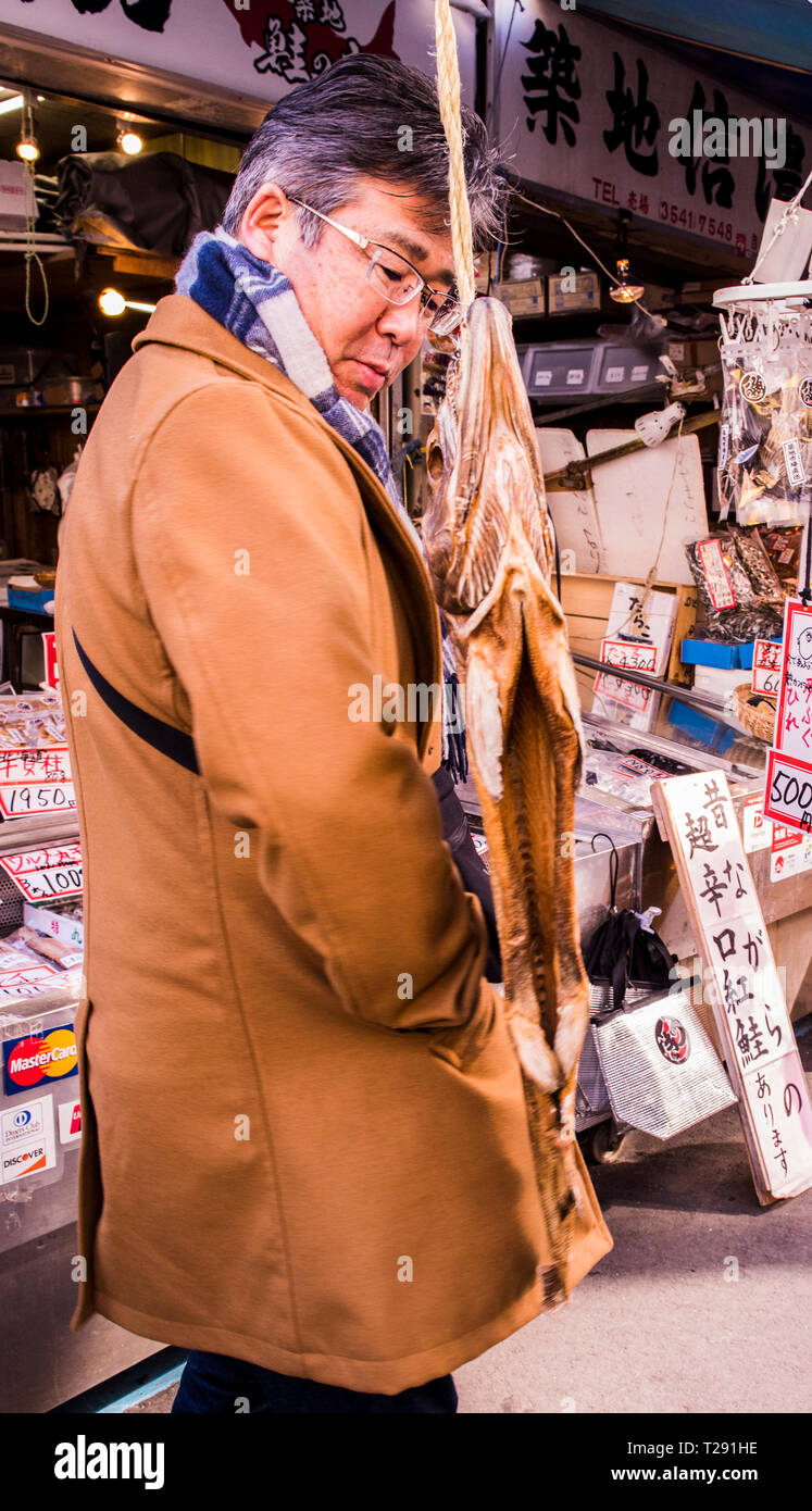 Man looking at goods at Tsukiji Fish Market, Tokyo, Japan Stock Photo