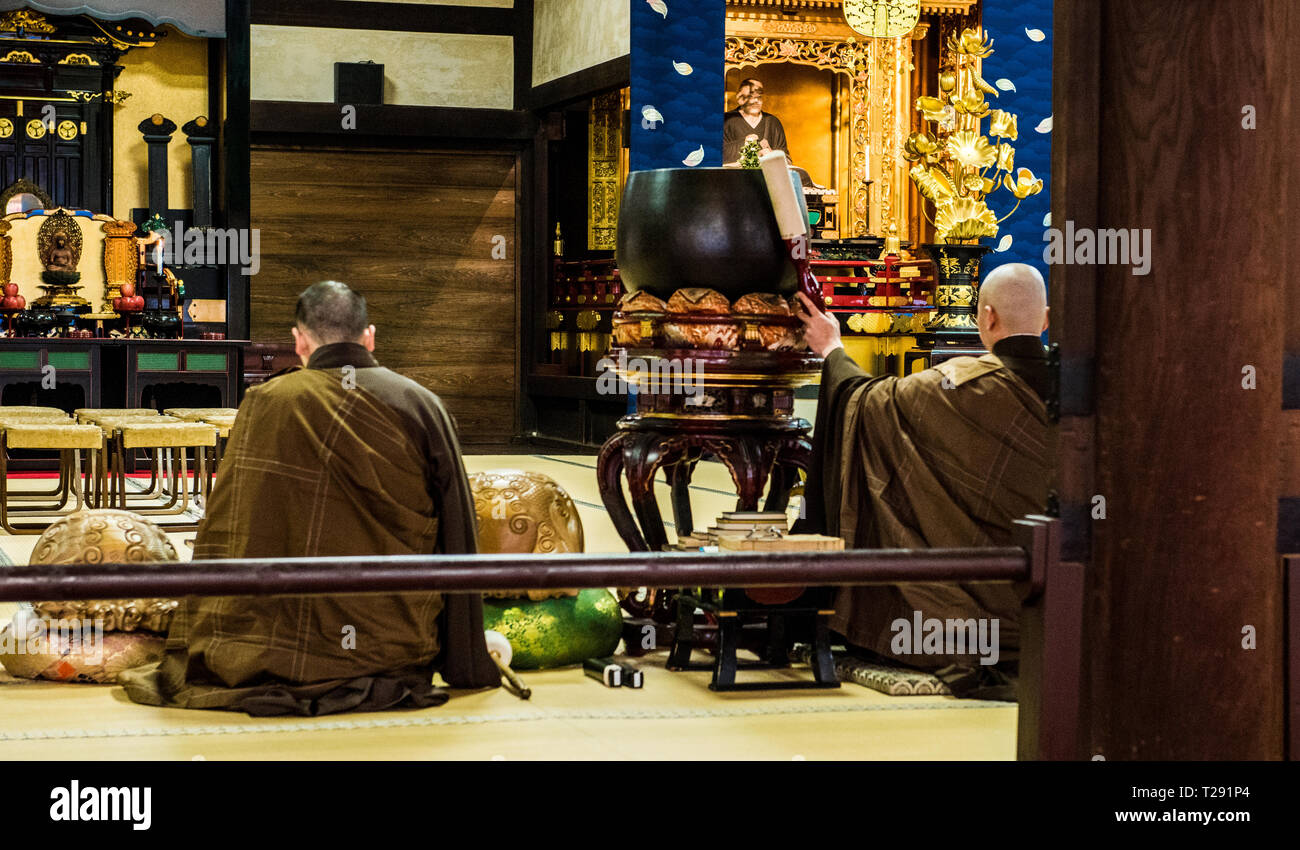 Buddhist monks, sitting inside Chion-in Temple, rear view, Kyoto, Japan Stock Photo