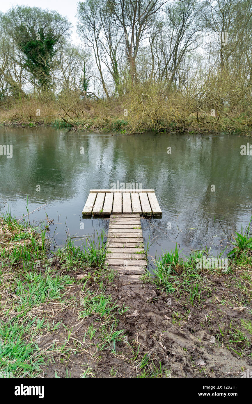 Small wooden jetty at the edge of a river Stock Photo
