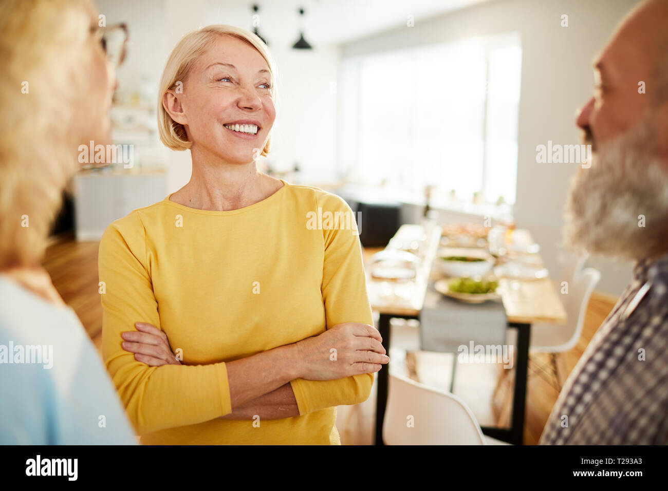 Positive friends chatting in dining room Stock Photo