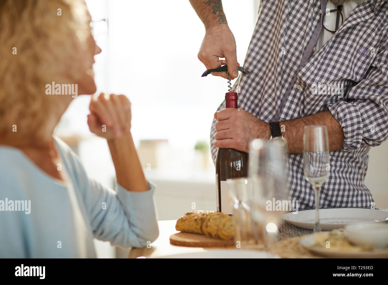 Using corkscrew to open wine bottle Stock Photo Alamy