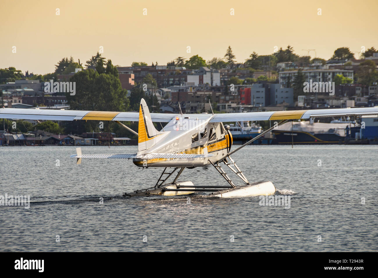 SEATTLE WA, USA - JUNE 2018: De Havilland Beaver float plane operated by Kenmore Air leaving the terminal in Seattle at dawn taxiing for take-off Stock Photo