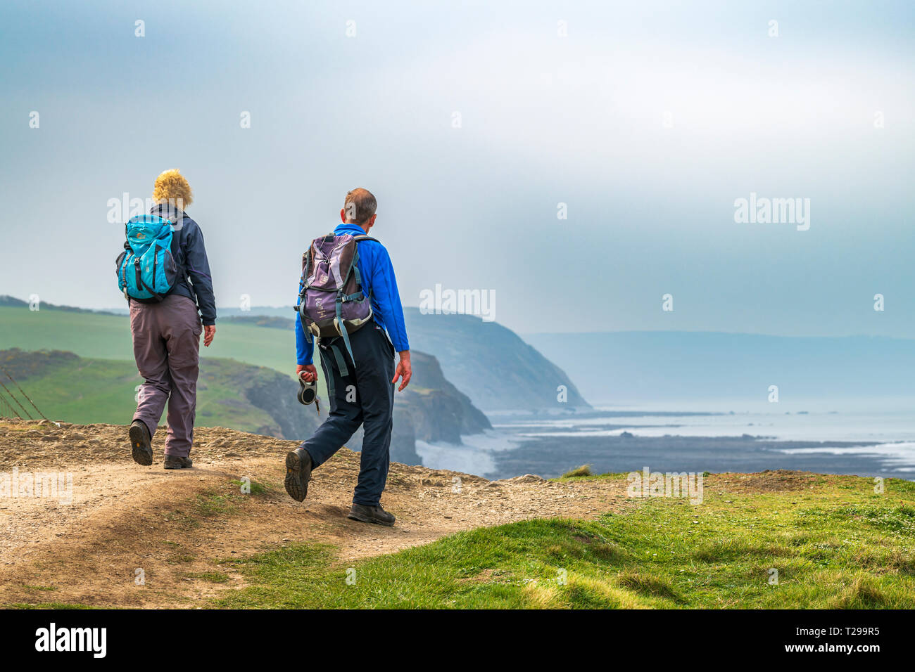 Devon, UK. 31st Mar, 2019. Uk Weather - 31st March. On a chilly afternoon at the end of March, a couple admire the view as they walk along the South West Coastal Path near Abbotsham in North Devon. Credit: Terry Mathews/Alamy Live News Stock Photo