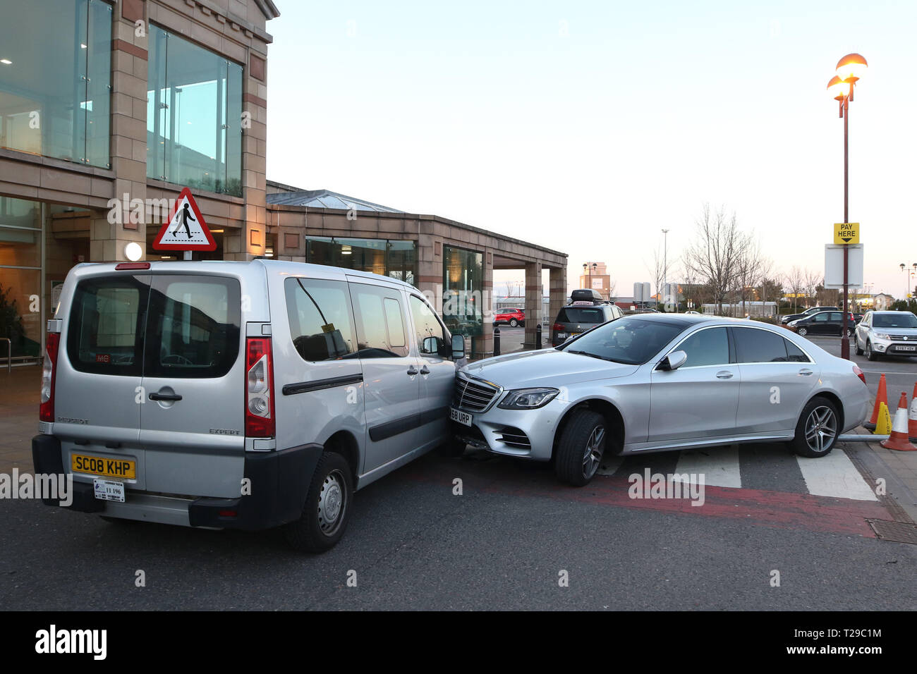 Inverness, UK. 31st Mar, 2019. 31 March 2019: Scene of a road traffic collision at the entrance to Morrisons supermarket in Inverness. A silver Mercedes was in collision with a silver Peugeot taxi. The driver of the taxi said that the 45-year-old driver of the automatic Mercedes, who had a New York State driving licence registered to a New York address, was attempting to park in a disabled bay when the car suddenly went forward across a pedestrian area, knocked down a parking ticket machine which became trapped under the car, and then crossed the zebra crossing and hit the taxi. Picture: Andre Stock Photo