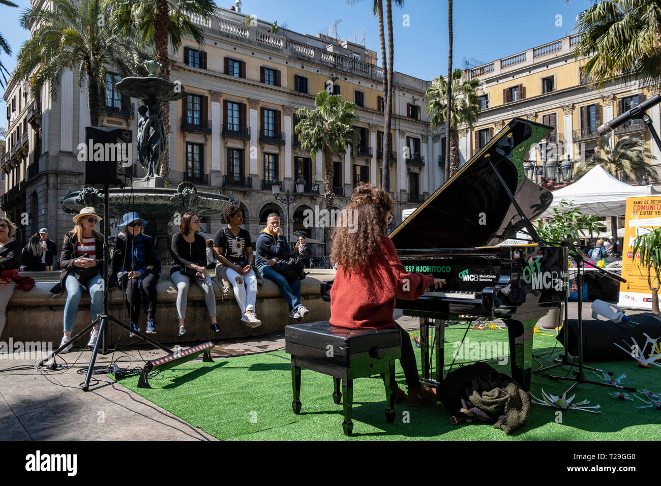 A woman is seen playing a grand piano in the Plaza Real in Barcelona. Grand  pianos have been placed in various public spaces of Barcelona at the  disposal of anyone who wants