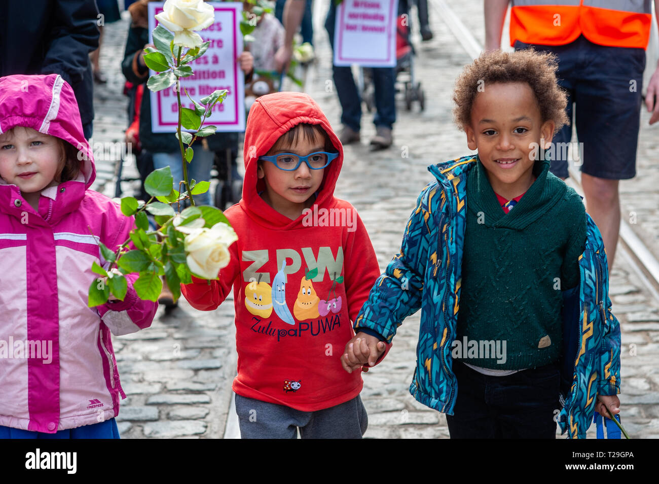 Kids are seen walking while holding a white rose during the March for Life in Brussels. Thousands of people gathered at the Poelaert during The 10th edition of the March for Life in Brussels, to defend the respect of human life from conception to natural death. The march was surrounded by a lot of police because of the pro-abortion demonstration that also took place closer to the march. Stock Photo