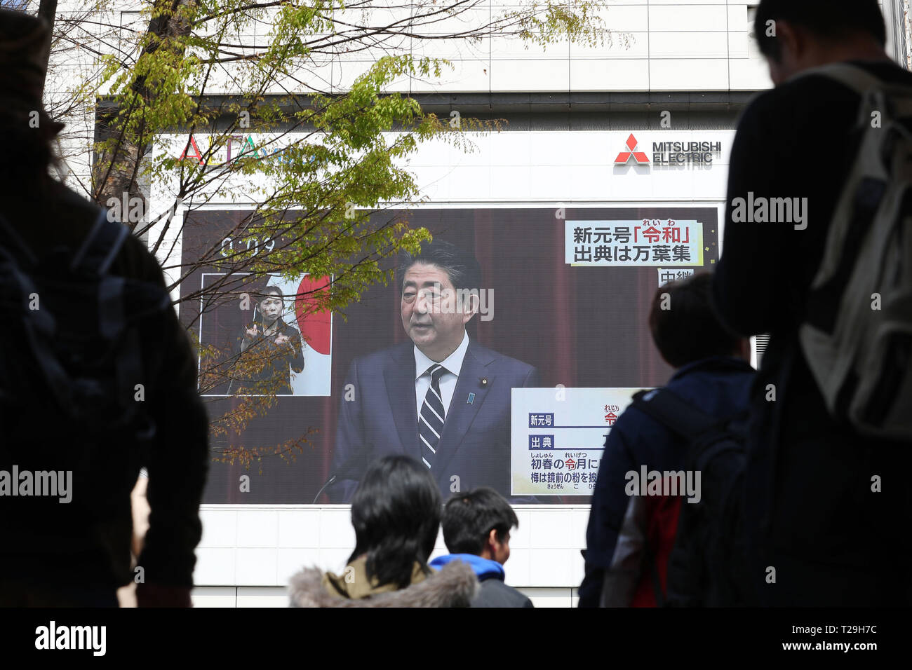 Tokyo, Japan. 1st Apr, 2019. People watch a large screen showing Japanese Prime Minister Shinzo Abe's announcement about the name of the new Imperial era, 'Reiwa,' in Tokyo, Japan on April 1, 2019. The Japanese government officially announced the country's next era will be known as the 'Reiwa' era on Monday, a month before Crown Prince Naruhito ascends the throne following Emperor Akihito's abdication. Credit: Yohei Osada/AFLO/Alamy Live News Stock Photo