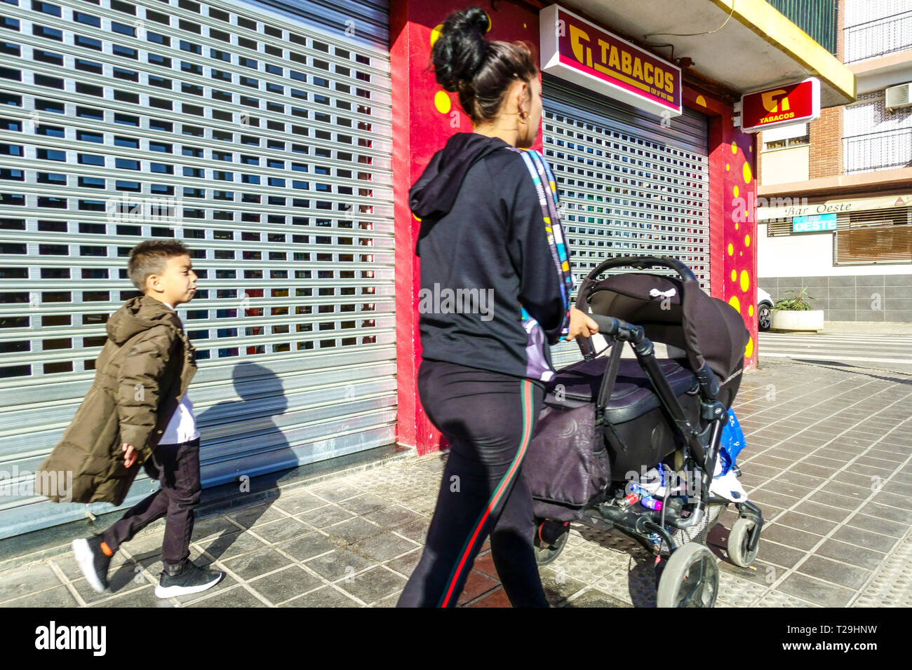 Youn women with son and with the stroller, Street of Valencia, Quart de Poblet district, Spain Stock Photo