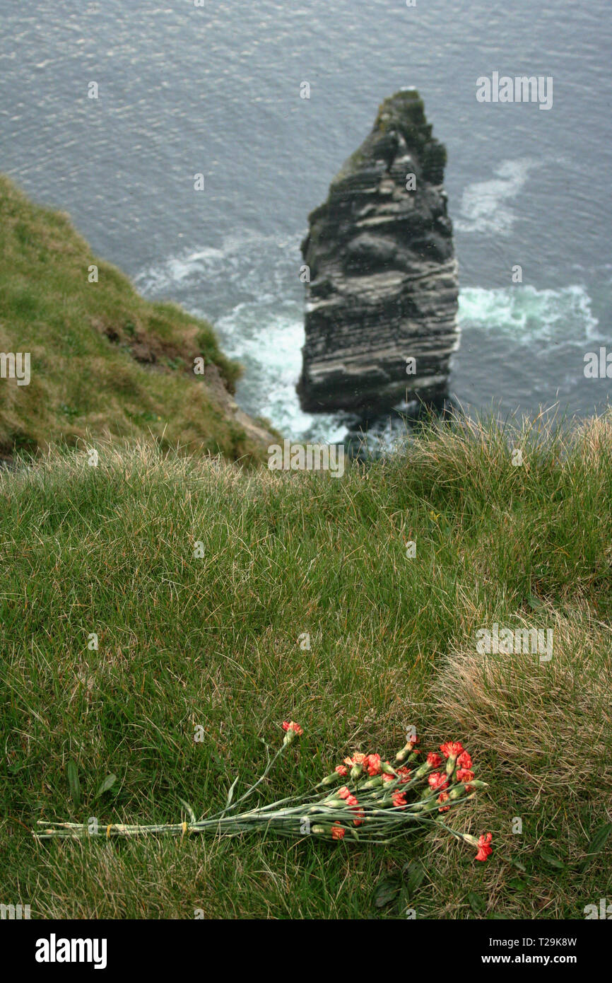 Mourning bouquet at the edge of Cliffs of Moher where several suicides occur yearly. This is also place where death selfie is known. Stock Photo