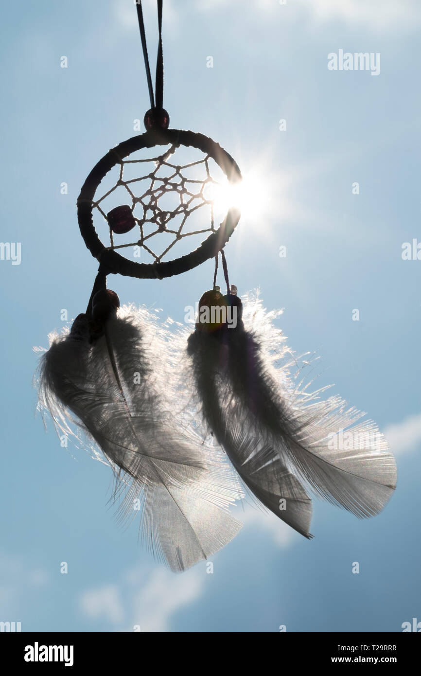 A dream catcher silhouetted against the sun with the sun streaming through. Stock Photo