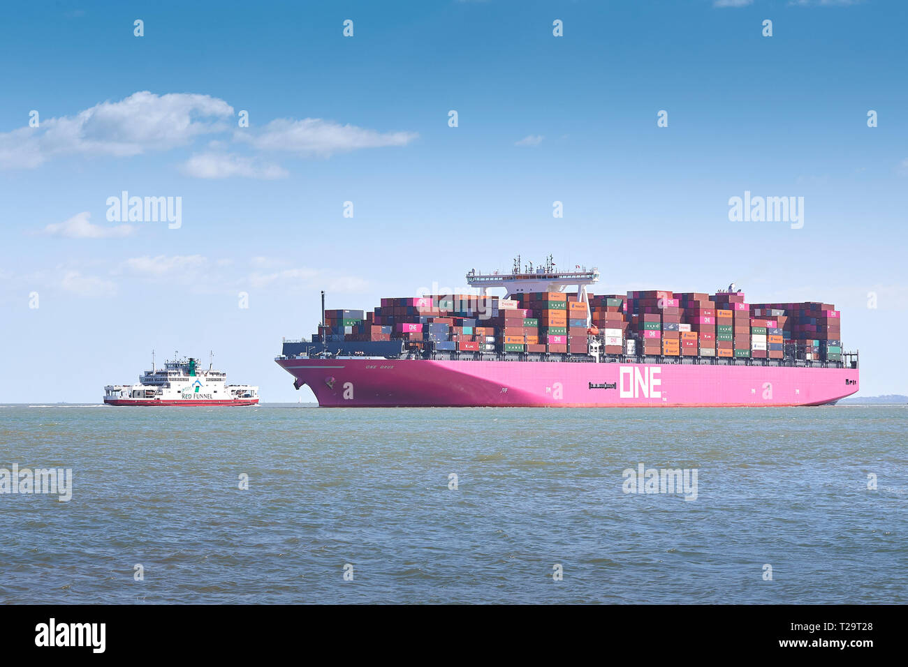 The New, Ocean Network Express Container Ship, ONE GRUS, Passing A Red Funnel Ferry As It Approaches The Port Of Southampton, UK. 25 March 2019. Stock Photo