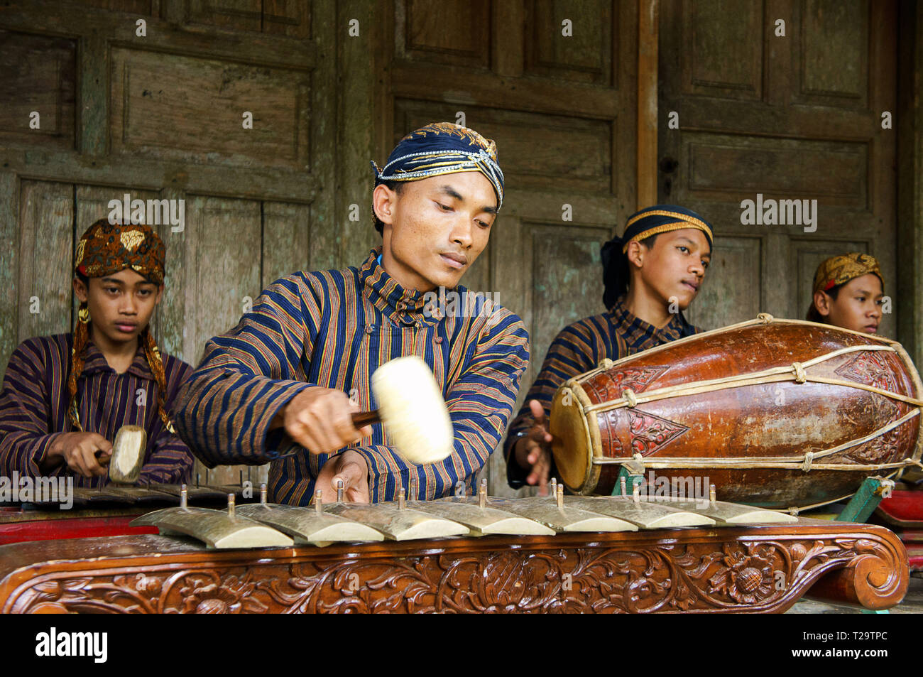 A group of youth playing Javanese gamelan with using blangkon, lurik and traditional clothes Stock Photo