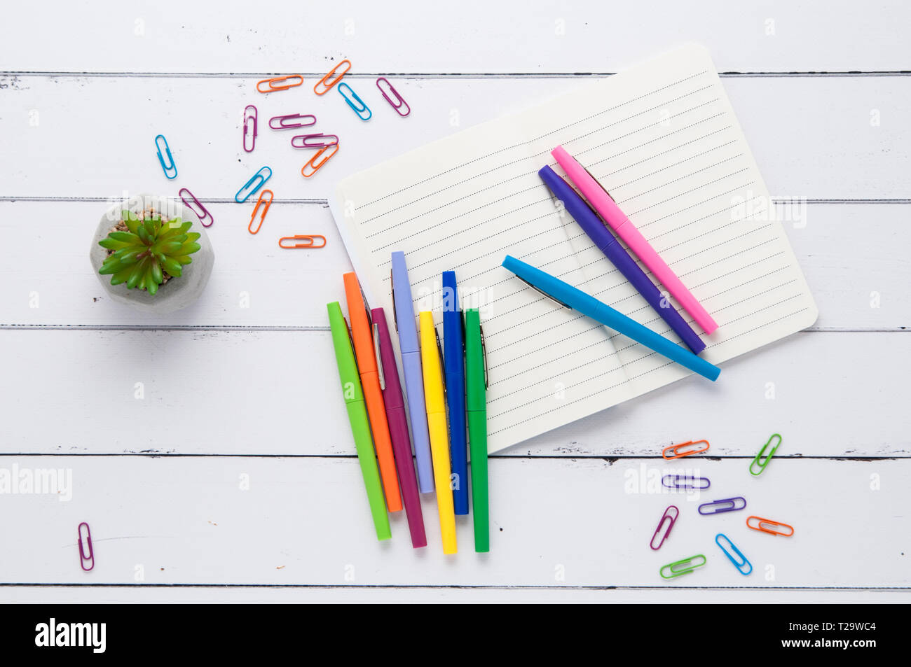 colorful pens on a wooden tabletop with a notebook Stock Photo