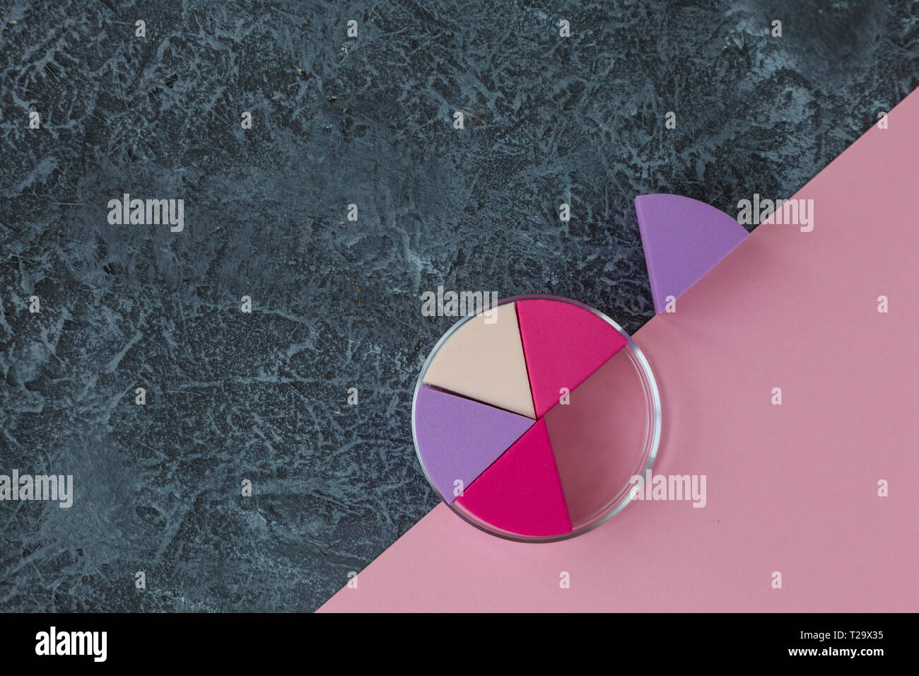 Make up sponges on dark stone background. Cosmetic applicator. Pink paper with copy space Stock Photo
