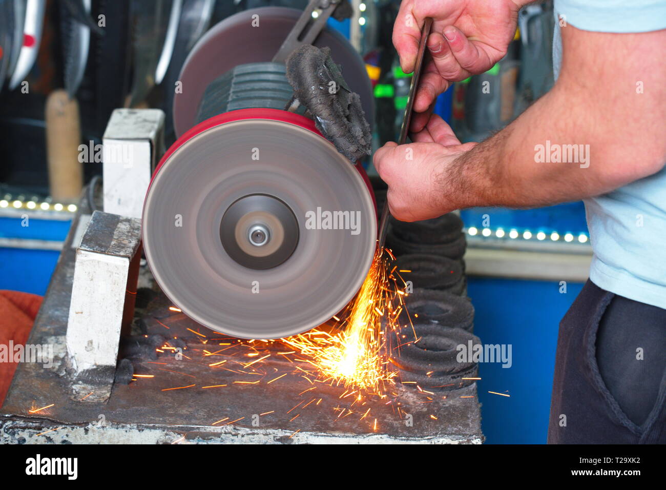 Sharpening knife on old grindstone wheel Stock Photo - Alamy