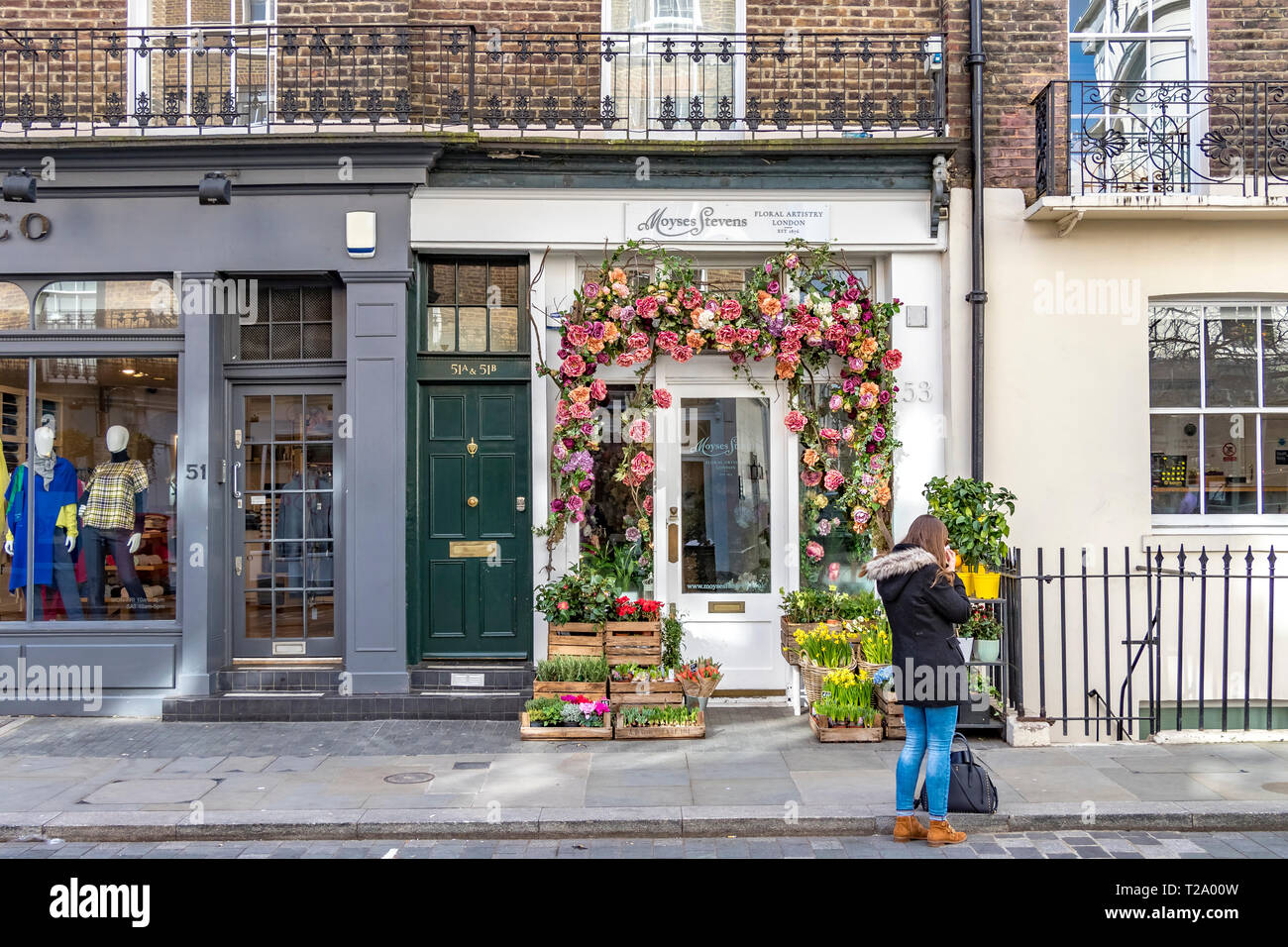 A woman standing outside Moyses Stevens Floral Artistry shop in Belgravia ,London, UK Stock Photo