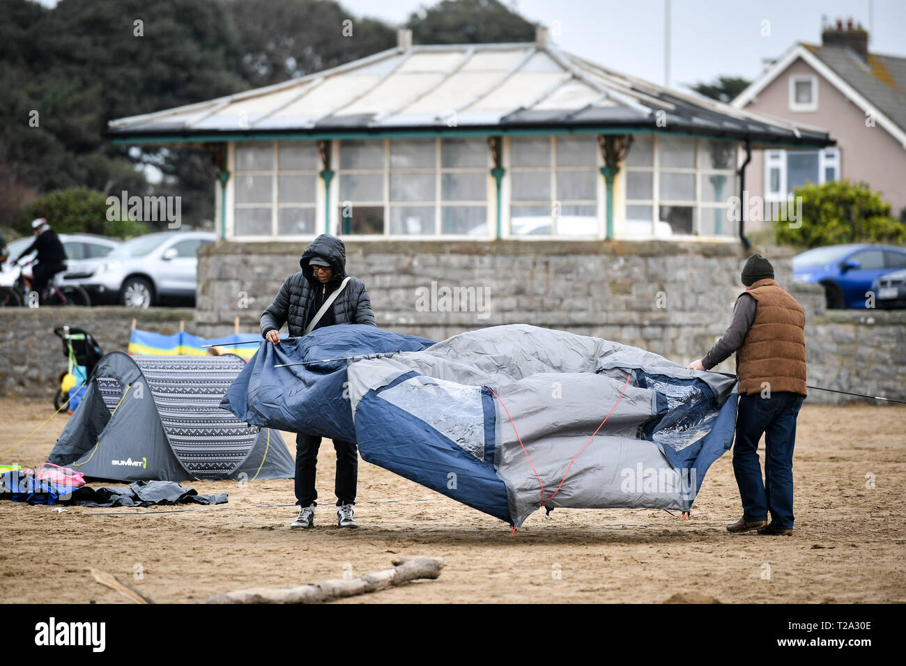 People pitch a tent in the wind on the beach at WestonsuperMare Stock