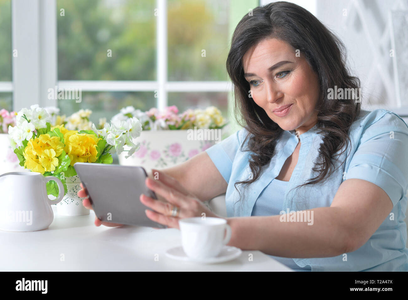 Beautiful mature woman using modern tablet Stock Photo