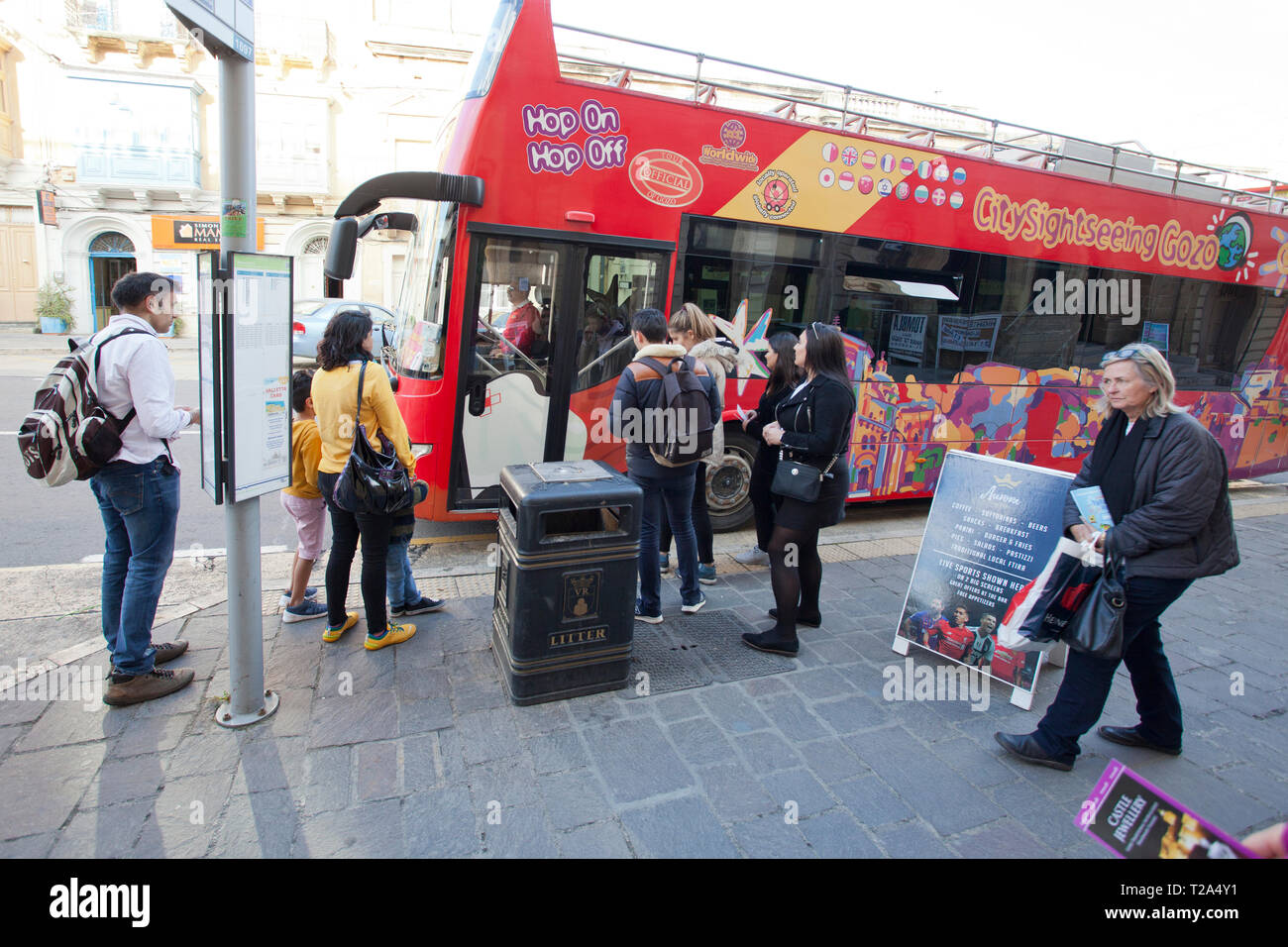 Passengers board a hop on hop off bus in Gozo for sight seeing Stock Photo