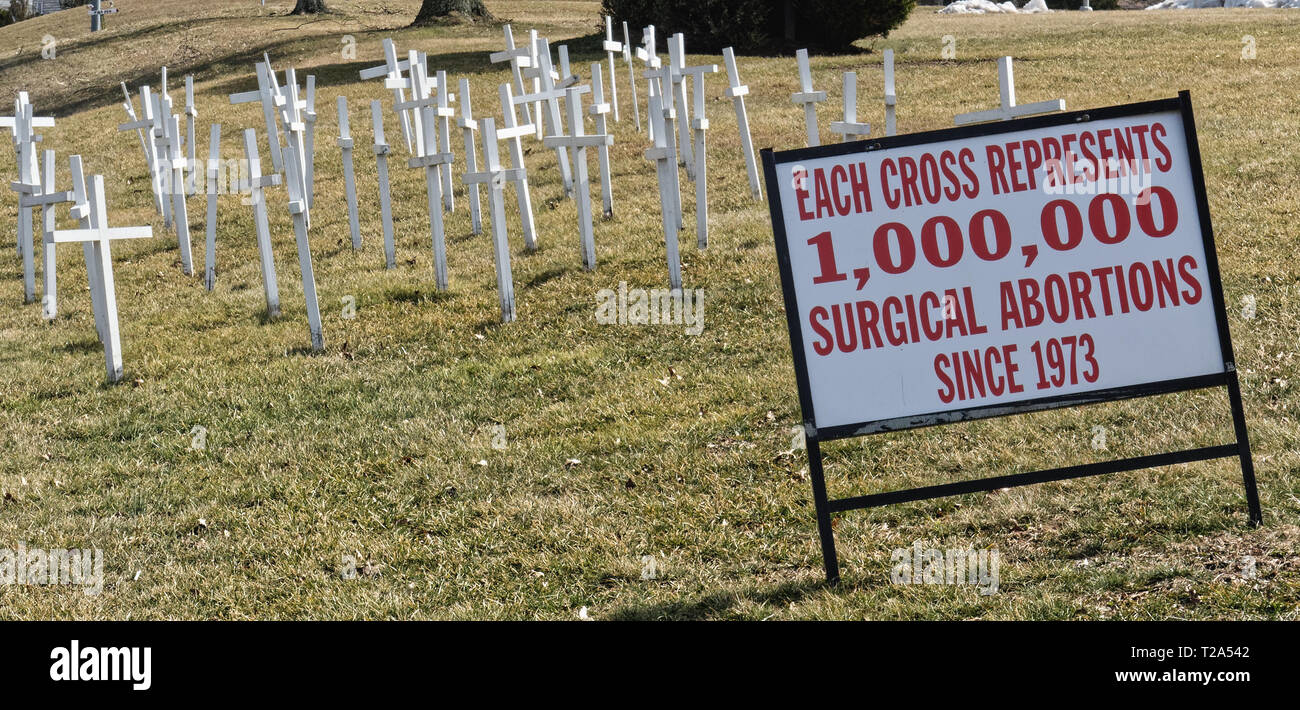 Lansdale, PA - March 14, 2019: White crosses on a hillside in front of a church with a sign that says 'Each Cross Represents 1,000,000 Surgical Aborti Stock Photo