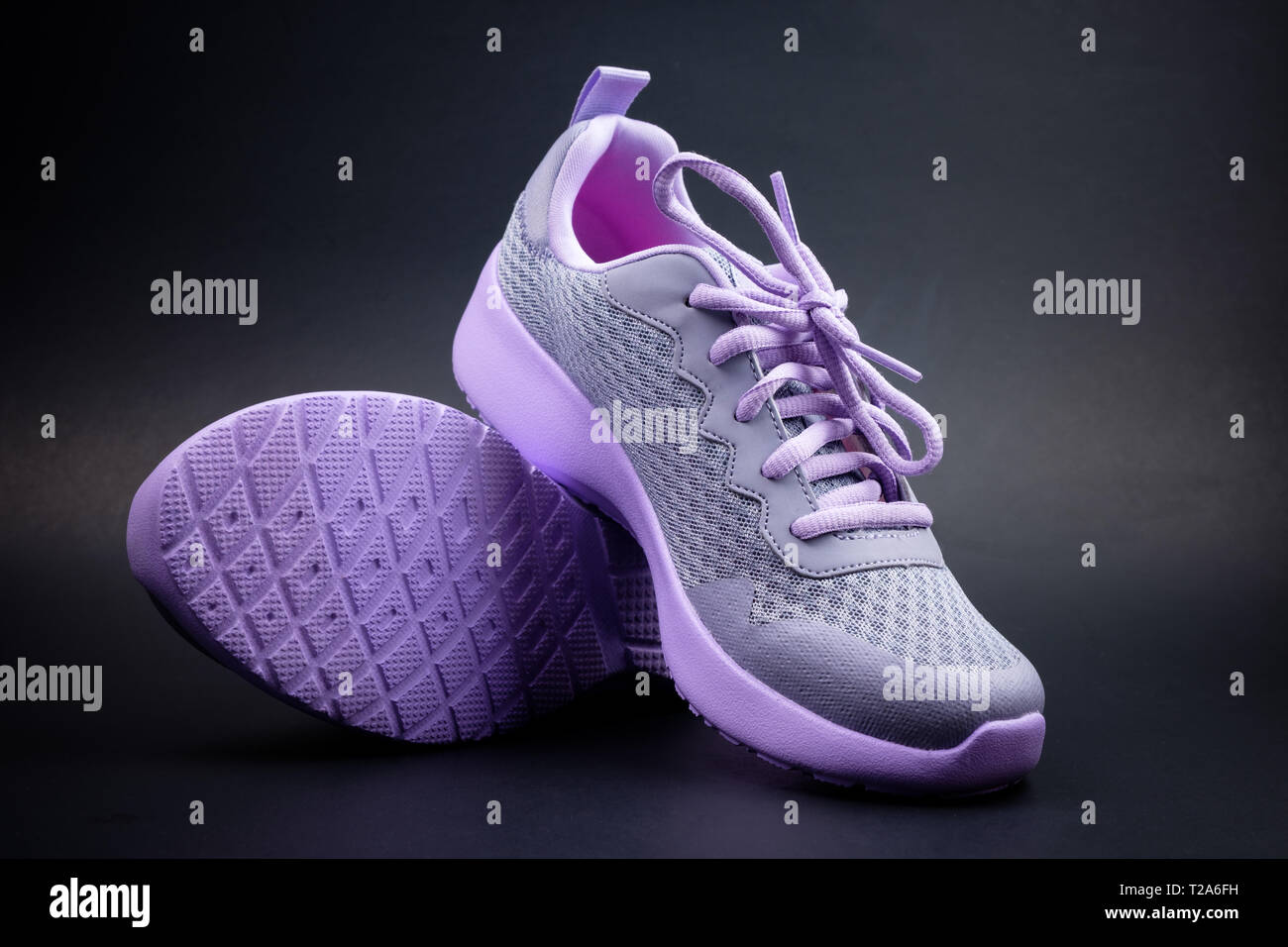Unbranded purple running shoes on a black background Stock Photo