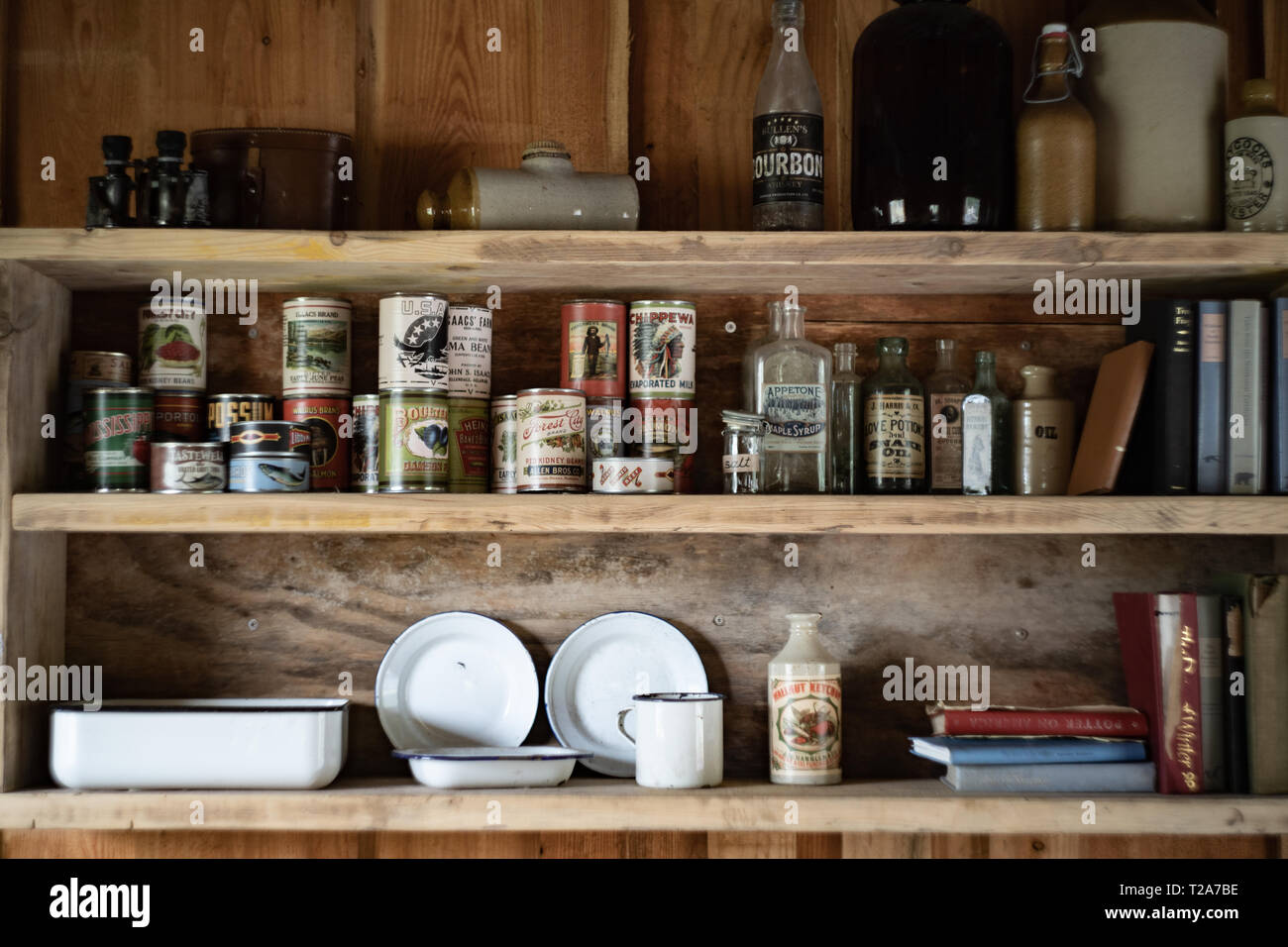 Shelf with old / traditional North American food tins and bottles on a shelf in a trapper's hut / cabin Stock Photo