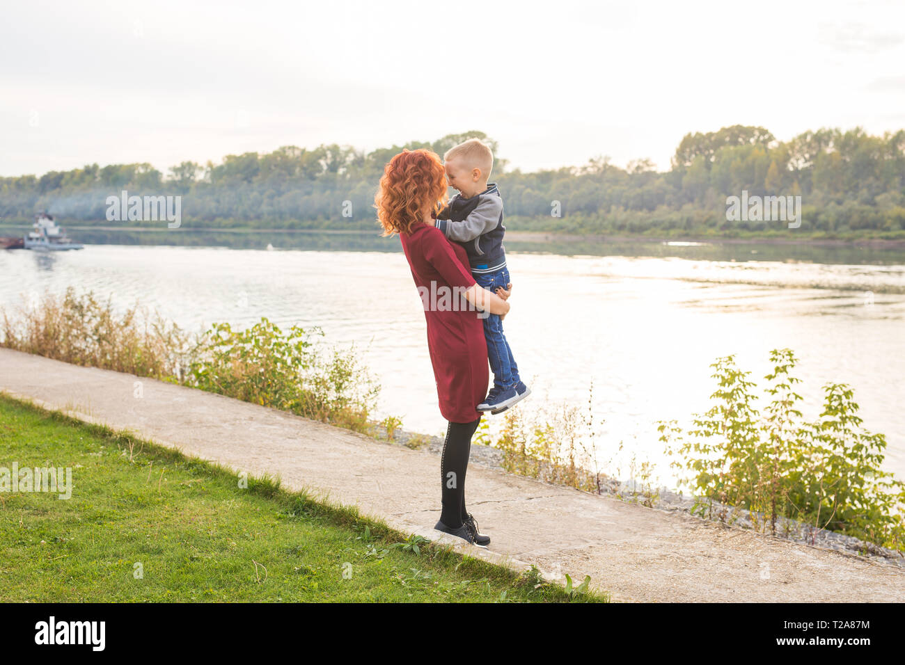 Motherhood and children concept young mother with son in her arms