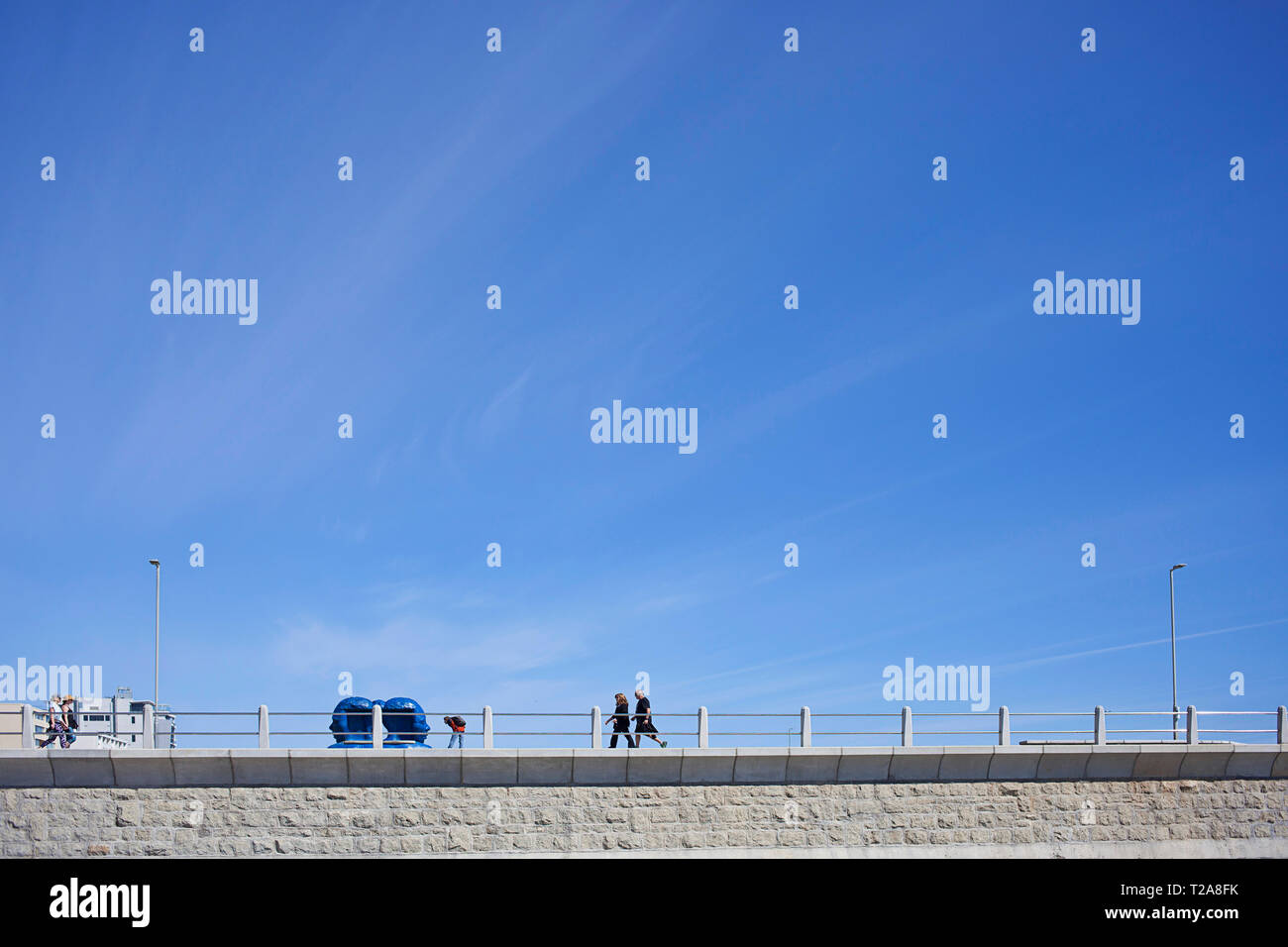 Minimalist view of couples walking along promenade Stock Photo